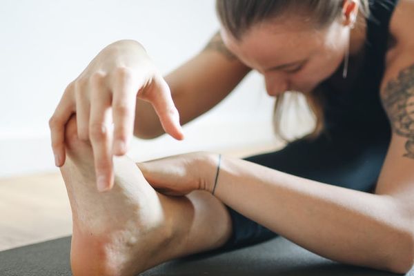 Woman gently stretching, practicing yoga at home.